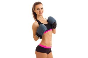 a young athletic girl stands in boxing gloves looks into the camera and smiling photo