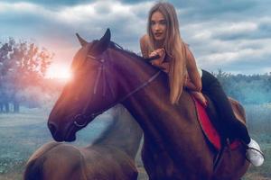 hermosa chica se acuesta encima del caballo y mira a la cámara foto