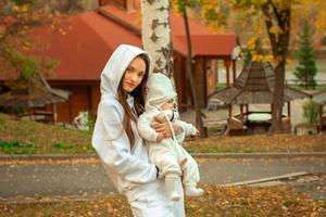 hermosa joven madre con bebé en otoño foto