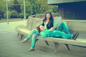 Girls resting on a bench photo