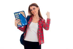 beautiful young students girl with backpack and folders for notebooks in her hands smiling on camera isolated on white background photo
