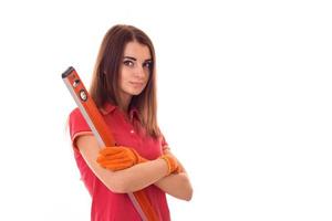 attractive young brunette builder girl in uniform makes renovation with tools in her hands isolated on white background photo