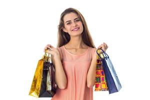 young girl smiling and holding colorful shopping bags isolated on white background photo