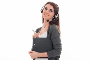 cute young girl with headphones is smiling looks away and keeps the folder in the hands photo