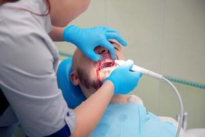 niño limpia una placa en una recepción en el dentista foto