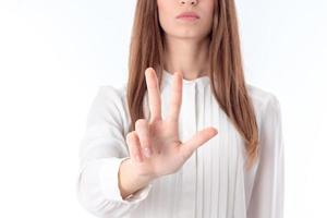 la chica de la blusa blanca extendió una mano y tres dedos muestran un primer plano foto