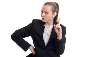 young beautiful business woman in black jacket keeps her hand on the side shows the gesture and looks into a camera photo