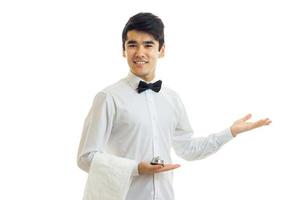 handsome young waiter extended a hand to the side and smiling photo