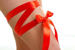 sexy female legs with red ribbon background photo