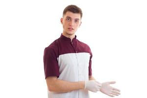 médico joven en uniforme y guantes mirando a la cámara foto