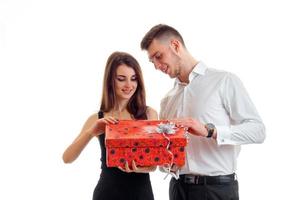 smiling cute girl standing next to a guy and opens a gift photo