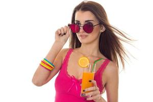 retrato de verano de una joven encantadora con ropa ligera y gafas de sol con un cóctel en las manos posando aislada de fondo blanco foto