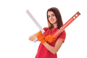 pretty young slim builder girl makes renovations with tools in her hands isolated on white background photo