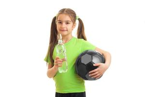 Little cute girl drinks water after a football play photo