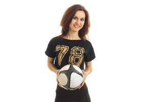 smiling young woman in a black t-shirt looks straight and holds the ball photo