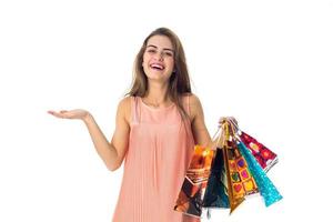 girl spreads her hand and keeps a lot of colorful packages with purchases isolated on white background photo