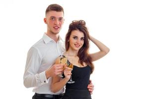 young smiling guy with girl, look right and carrying champagne glasses photo