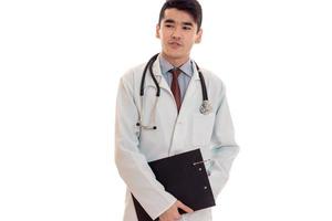 Retrato de estudio de joven médico masculino en uniforme posando aislado sobre fondo blanco. foto