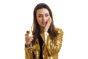 fashionable young brunette in a gold jacket holds glasses photo
