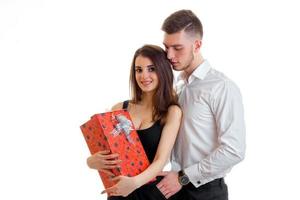 guy hugs a beautiful girl and give her a big red gift box photo