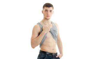 young sexy guy with a nice torso raises hand their shirt and looking at camera photo