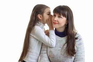 Portrait of a young mother and daughter who sets the secrets on the eyelet is isolated on a white background photo