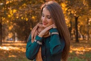 cute girl is worth turning sideways in the Park and keeps hands near the face photo