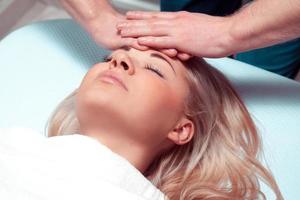 Masseur doing massage the head of caucasian woman in the spa salon photo