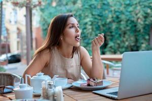 young woman eats delicious cake photo