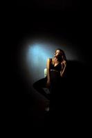 Gorgeous lady with curly hairstyle in dark studio photo