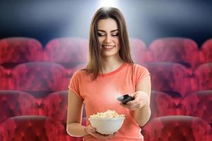 Cheerful lady with pop corn in hand smiles photo