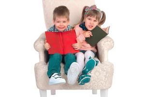Children sit in a chair with books photo