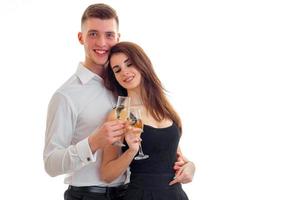 beautiful young girl smiling closing her eyes stands next to a cute guy and they are holding wine glasses photo