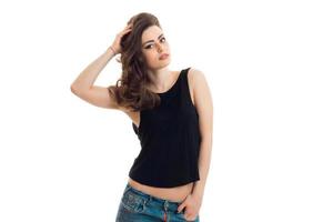 amazing young brunette in black t-shirt looks into the camera and holds hand hair photo