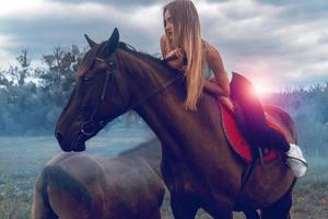 attractive woman lies on top of a horse photo