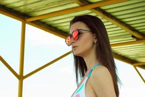 portrait of young girl in sunglasses and swimsuit photo