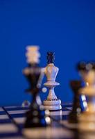 Chess board with chess pieces on blue background. Concept of business ideas and competition and strategy ideas. White and black kings close up. photo
