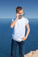 ashionable boy in sunglasses on the beach photo