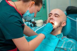 hombre cuidando sus dientes de cheques de salud en el dentista foto