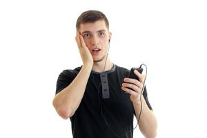 el joven guarda el teléfono con auriculares y tomó la pelota detrás de la persona foto