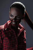 foto vertical de una chica adulta con un arte facial aterrador al estilo de halloween