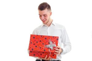 young smiling guy in the white shirt holding a big red gift photo