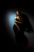 Gorgeous lady with curly hairstyle in dark studio photo