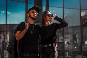 Adorable couple in sunglasses hugs in the street photo