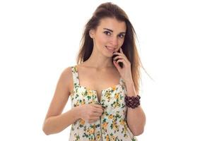 seductive young woman unbutton her sarafan with floral pattern and looking at the camera isolated on white background photo