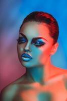 Fashion model in red and blue lights with healthy skin and makeup photo