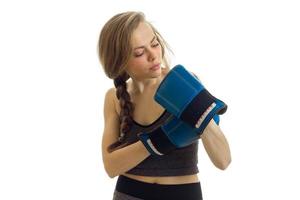 young gorgeous blonde stands with pigtail and stares at his hands in boxing gloves close-up photo