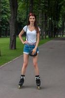 young charming brunette girl on rollers photo