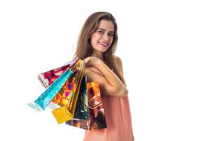 cute girl smiles and keeps the shoulder bags from stores isolated on white background photo