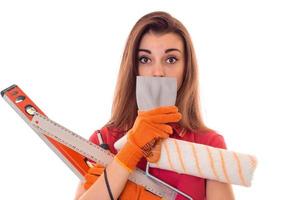 Encantadora joven en uniforme hace renovación aislado sobre fondo blanco. foto